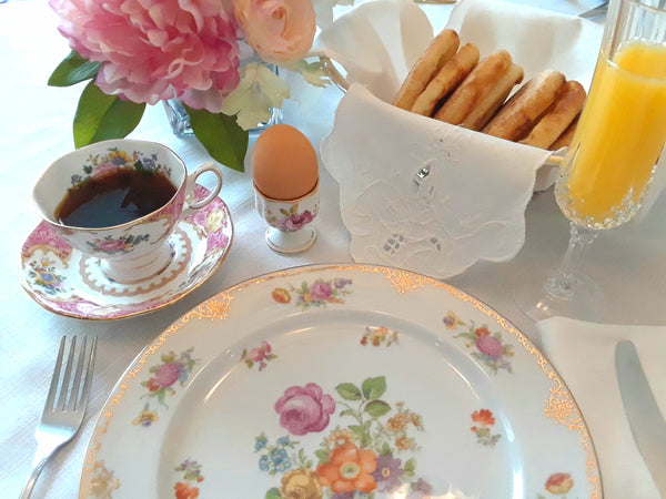 Royal Table Settings brunch setting with vintage egg cup, teacup and crystal champagne glass. Party Rentals by Royal Table Settings.
